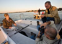 Meg Gaines takes to the open water as photographer Jeff Miller (foreground) and art director Earl Madden (right) prepare to capture our cover photo. Hoofers staff, in a second vessel tethered to the first, prepare to nudge the boat, as needed, into the changing light. Photo: Bryce Richter