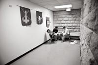 Privacy is minimal at the clinic housed in Grace Episcopal Church in downtown Madison, but the UW medical students do what they can with the available space. Above, in an exam “room” at the end of an L-shaped hall, student Tim Kufahl MDx’11 cares for a patient beneath church banners.