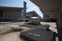 This 2012 photo shows discarded fencing outside the Olympic indoor pool and the OAKA sports hall, leftovers from the 2004 Olympic Games in Athens, Greece. It’s not unusual for such facilities to fall into disrepair when cities can’t afford to maintain them. Oli Scarff/Getty Images.