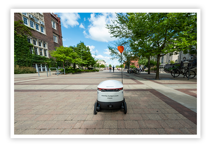 Robot heads toward the Memorial Union in the distance through Campus Mall