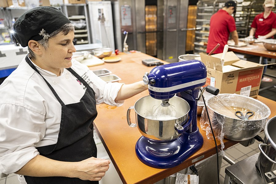 Pastry chef uses standing mixer to mix custard