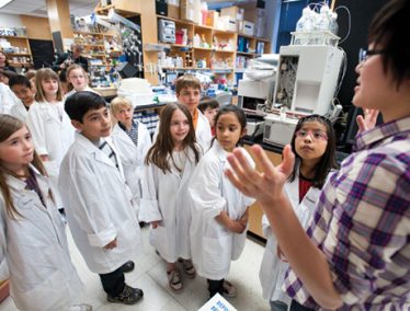 Researchers in the making listen intently as graduate student Jenna Eun ’07, PhDx’12 introduces them to Professor Doug Weibel’s research lab in the Biochemistry Building.