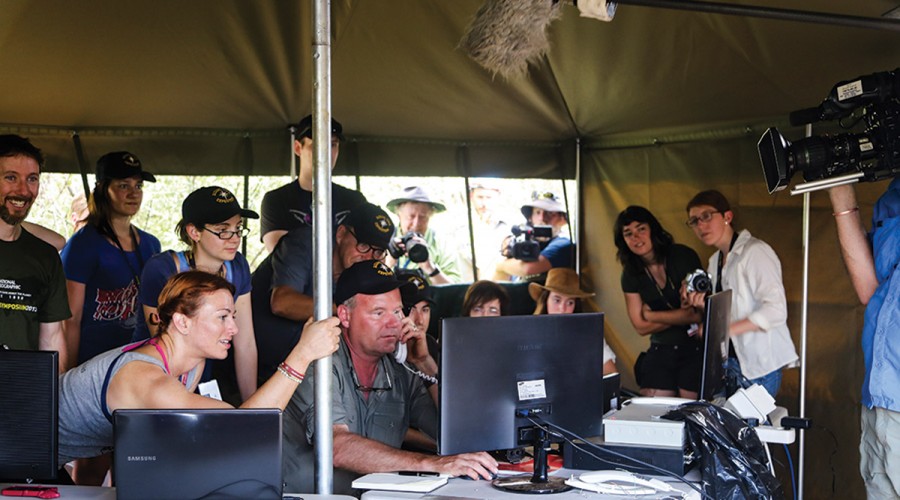 Lee Berger and others look at a computer screen