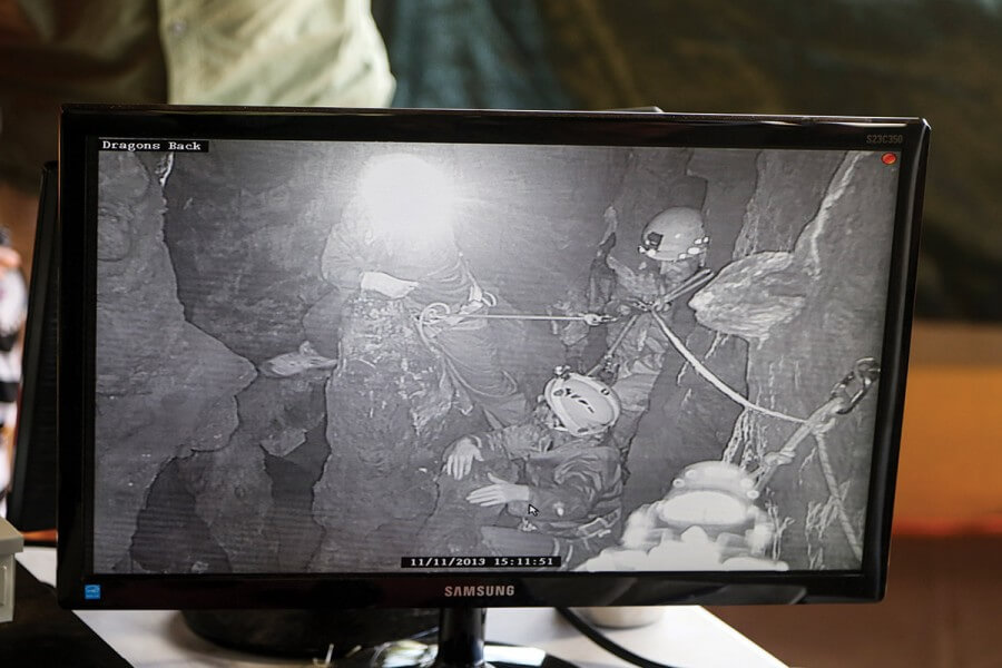 A video screen shows the cavers in the cave.