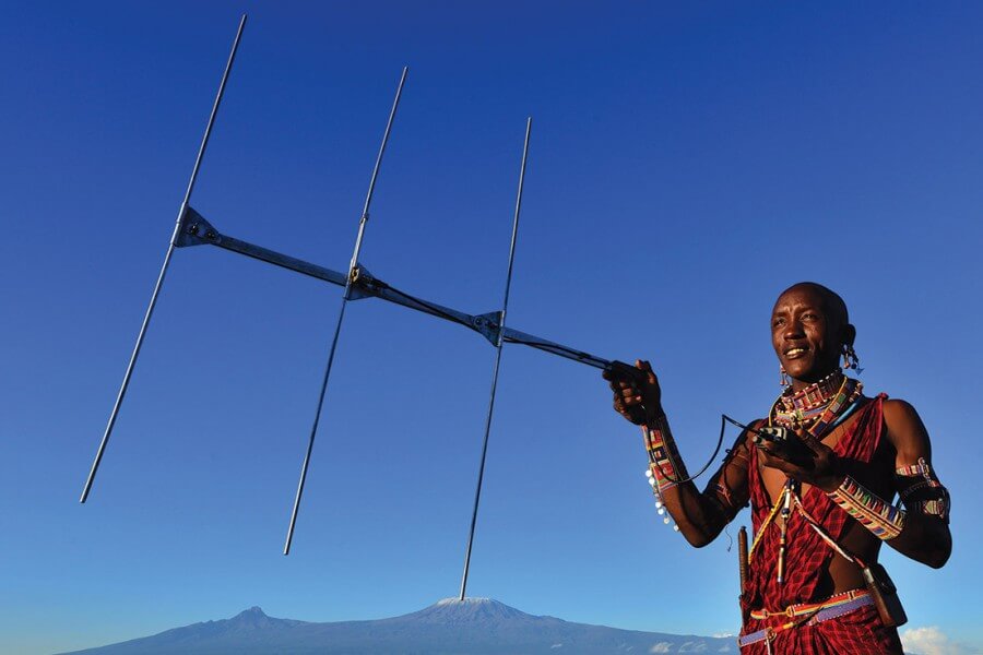 A Masai warrior uses an antenna to track lions