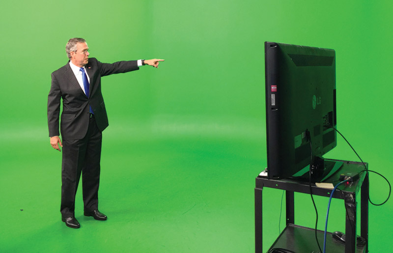 Jeb Bush standing in front of a green screen