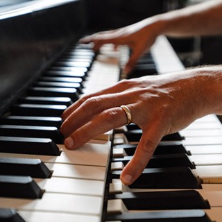 Christopher Taylor shows off the internal workings of the hyperpiano. The electronics inside the double- keyboard console connect to two separate pianos.