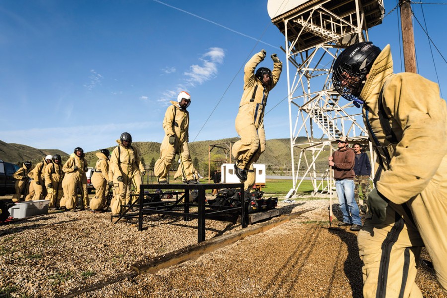 The firefighters participate in a warmup exercise intended to simulate jumping out of a plane.