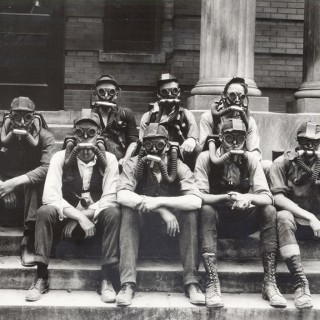 A group of student soldiers demonstrates gas masks. World War I was the first war to involve poison gas and UW researchers studied chemical warfare in the basement of Science Hall — an effort that was known as “the gas project.” In February 1918, the <em>Wisconsin Alumni Magazine</em> reported that UW scientists “have been working night and day to test the effects of gases and to devise automatic apparatus for detection of gases.” <span class=