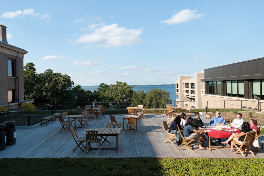 Several people gathered at patio table on outside deck at the top of Education building