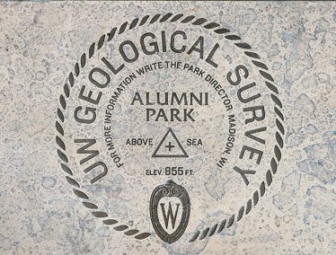 Brass plaque showing circular seal with text "UW Geological Survey, Alumni Park."