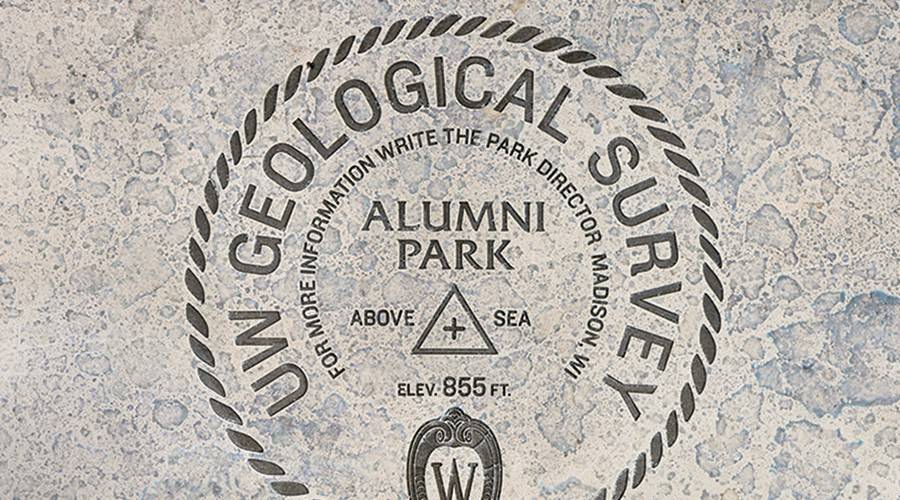 Brass plaque showing circular seal with text "UW Geological Survey, Alumni Park."