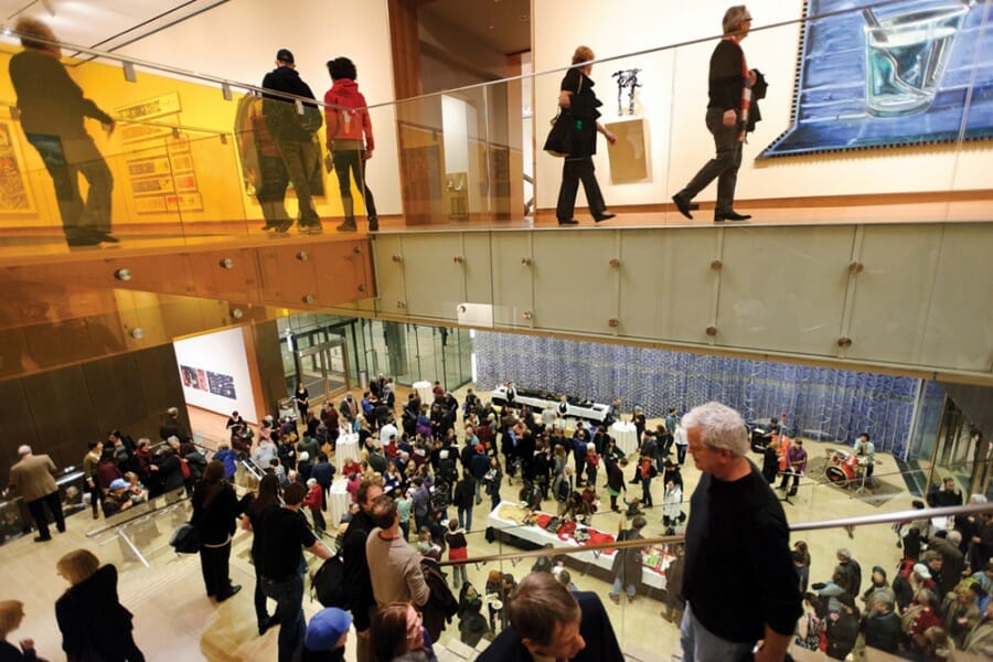 Crowds of visitors view exhibits on multiple floors of the Chazen Museum of Art.