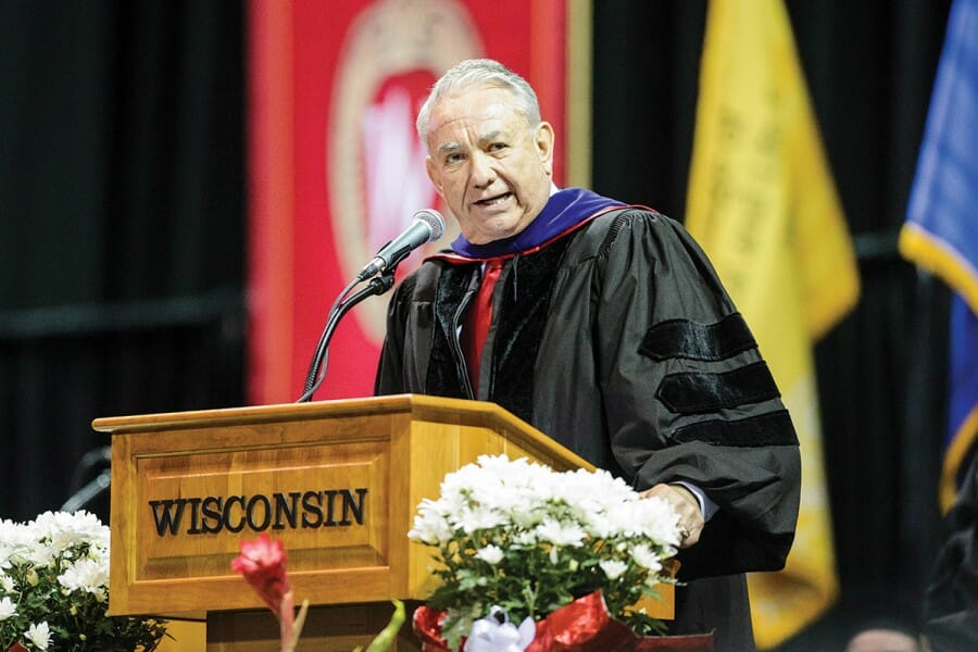 Tommy Thompson gives a speech at the podium at a UW Commencement ceremony