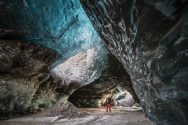 An explorer stands at the center of a gigantic ice cave in Iceland