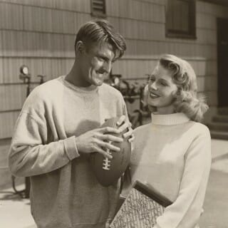 Elroy Hirsch holding a footbal and a female co-star in scene from movie, 