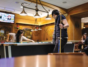 Two students play pool in the Memorial Union Der Stiftskeller