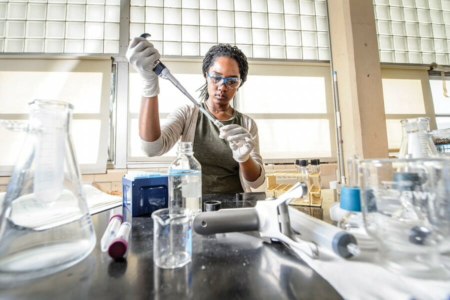 Coty Weathersby working in a lab, filling a test tube