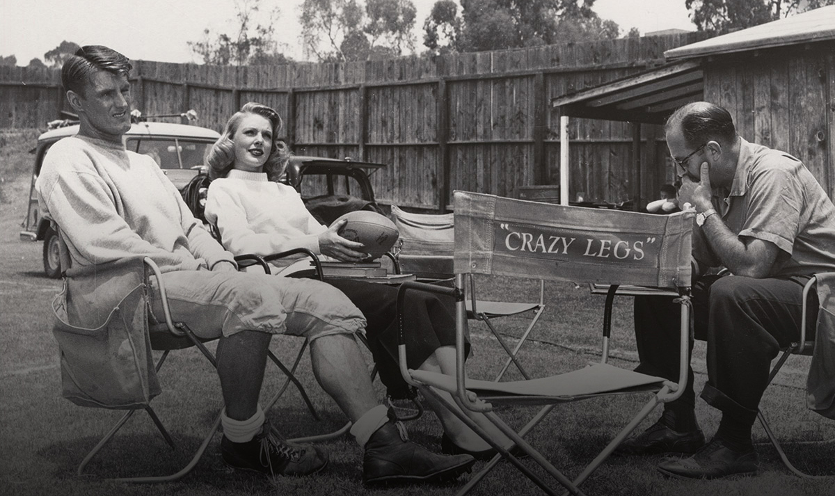 Elroy Hirsch relaxes on the set of the film Crazylegs with costar Joan Vohs and director Francis Lyon.