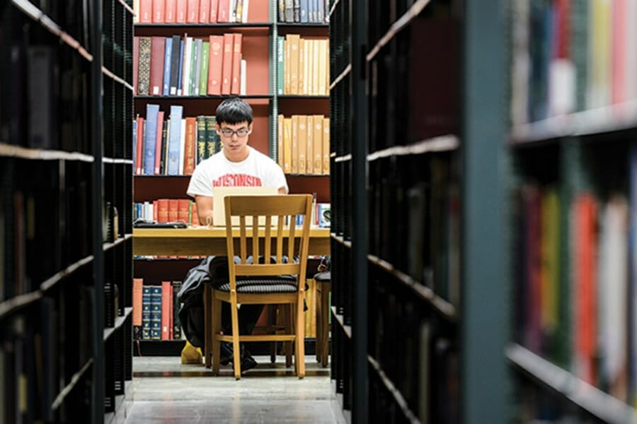 Student seated at table in one of the collections at Memorial Library on the UW–Madison campus