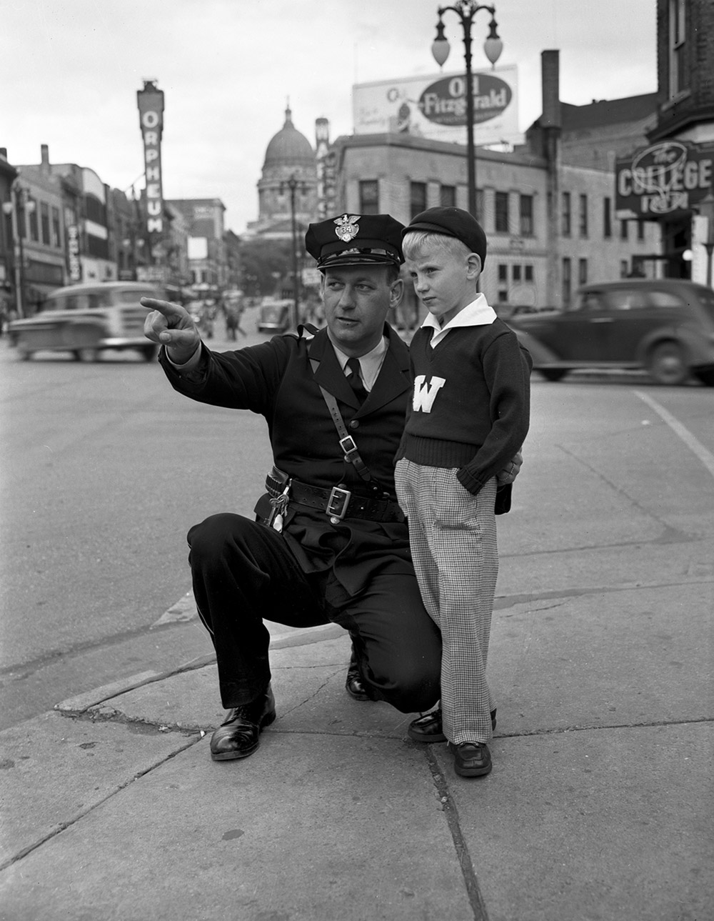 In 1949, Officer Hector Naze poses with a seven-year-old Milverstedt on a State Street corner in Madison, WI