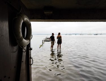 Students appear to walk on water at the flooded limnology pier on Lake Mendota.