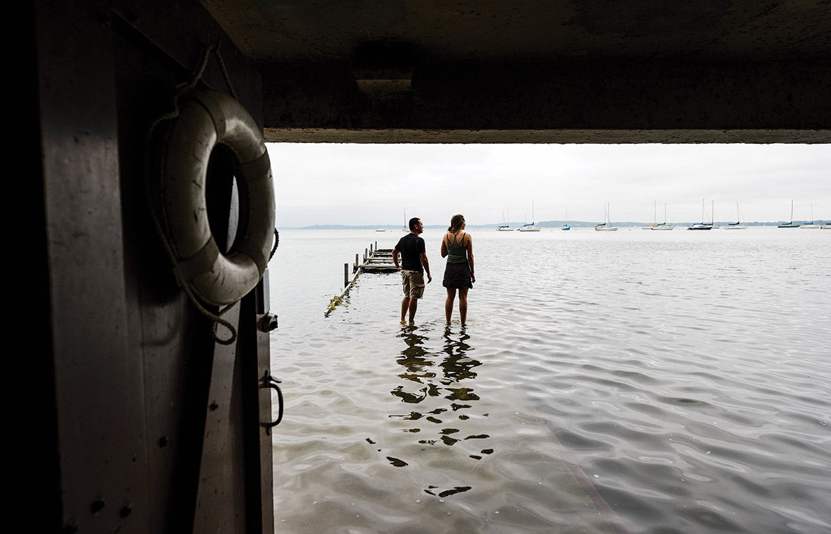 Students appear to walk on water at the flooded limnology pier on Lake Mendota.
