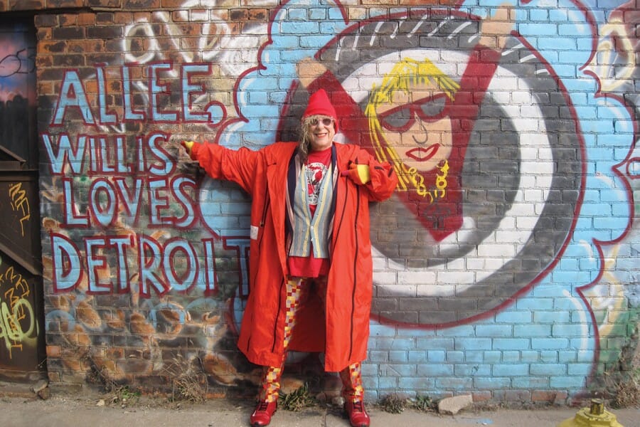 Allee Willis in front of a mural that reads "Allee Willis loves Detroit"