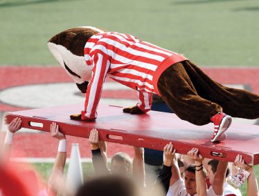Bucky Badger does push-ups at a football game