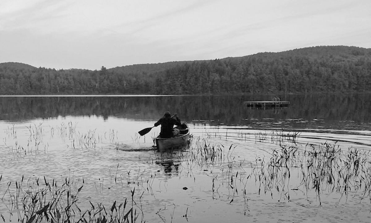 David Carr in a row boat at the family’s cabin in the Adirondacks