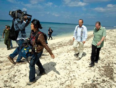Greenberg on a beach being filmed with Mexican president Felipe Calderón