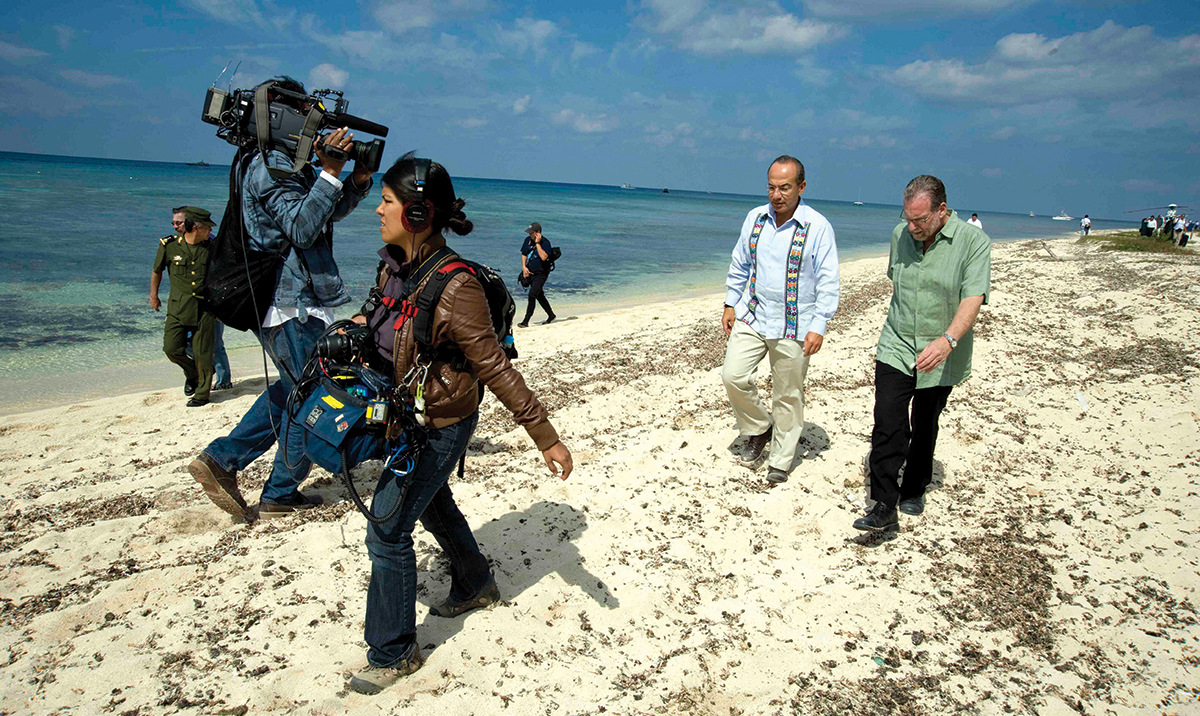 Greenberg on a beach being filmed with Mexican president Felipe Calderón