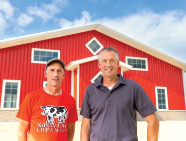 Robert and James Baerwolf in front of a red barn