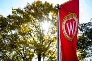 Sunlight shines through trees in background, UW-Madison banner in foreground