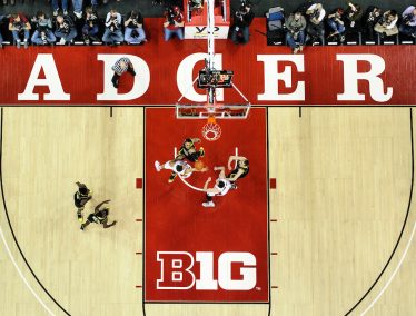 Birds eye view of Badger basketball team playing on the court at the Kohl Center