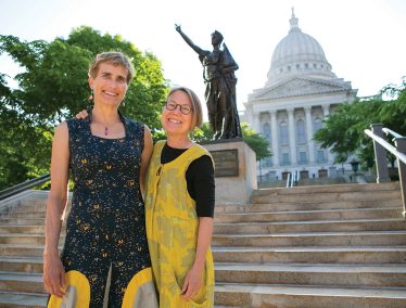 Brenda Baker and Bird Ross stand in front of the Wisconsin State Capitol Forward stature
