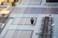 Masked pedestrian walks through empty campus