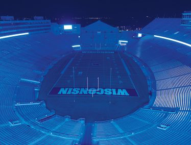 Empty Camp Randall stadium illuminated in blue light