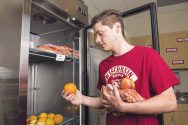Student selects food from a refrigerator