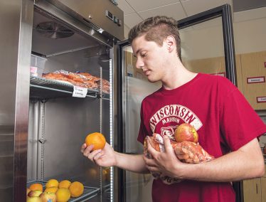 Student selects food from a refrigerator