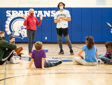 Physical Education teacher and student teacher instruct a grade school class