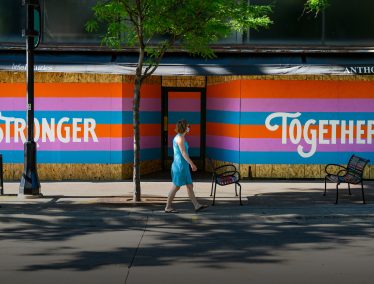 A painted mural reading "Stronger Together" is pictured on boarded up windows outside of the Little Luxuries and Anthology buildings on State Street in Madison
