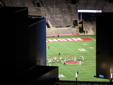 View of football game taking place with empty stands at Camp Randall