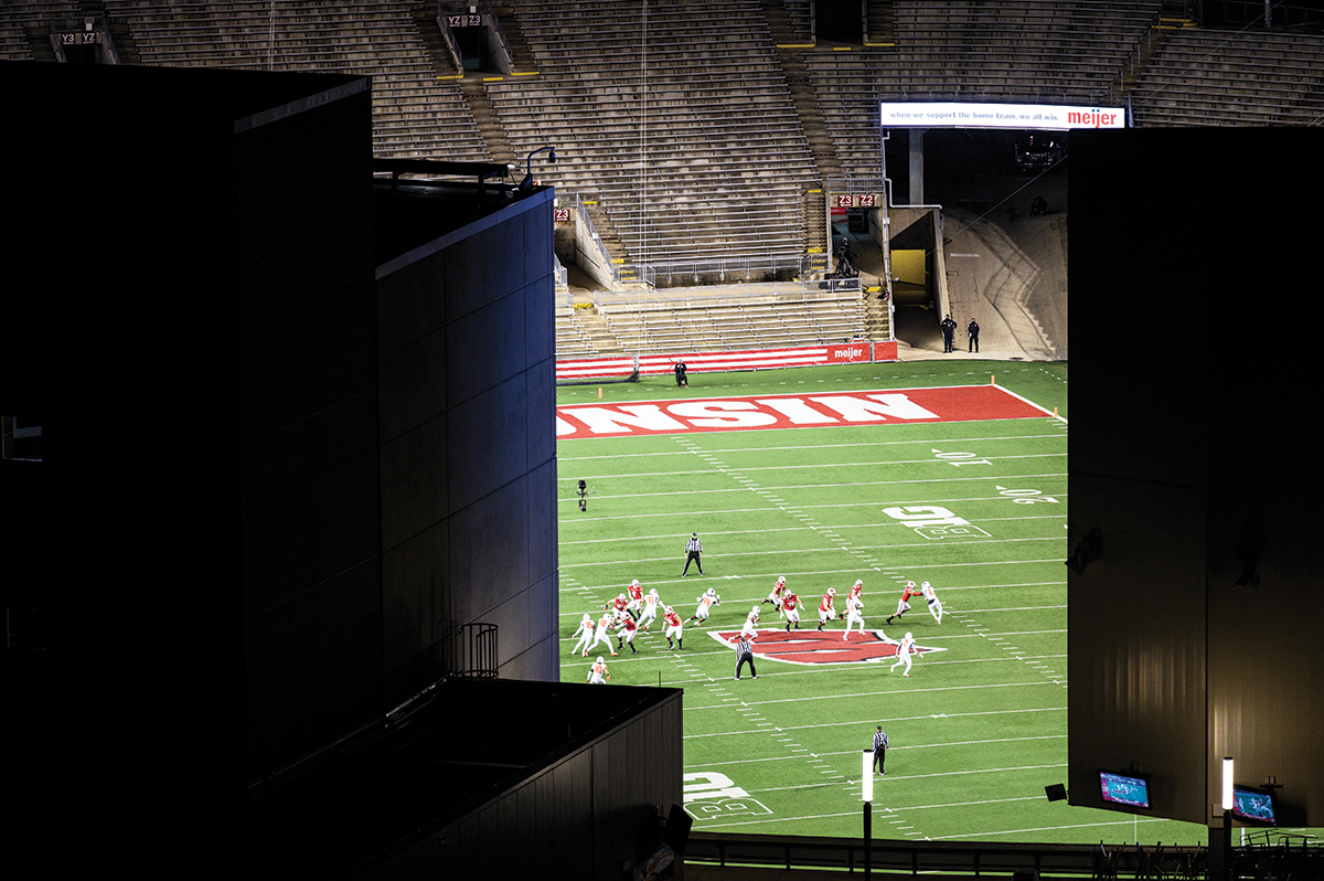 View of football game taking place with empty stands at Camp Randall