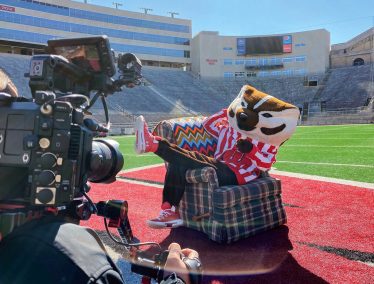 Bucky Badger poses for video camera on Camp Randall Field