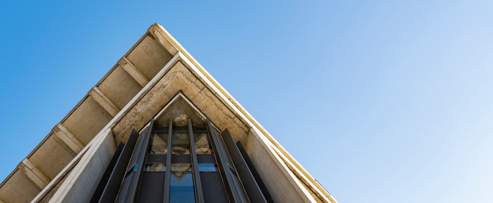 Photo of angular corner of the UW–Madison humanities building against blue sky