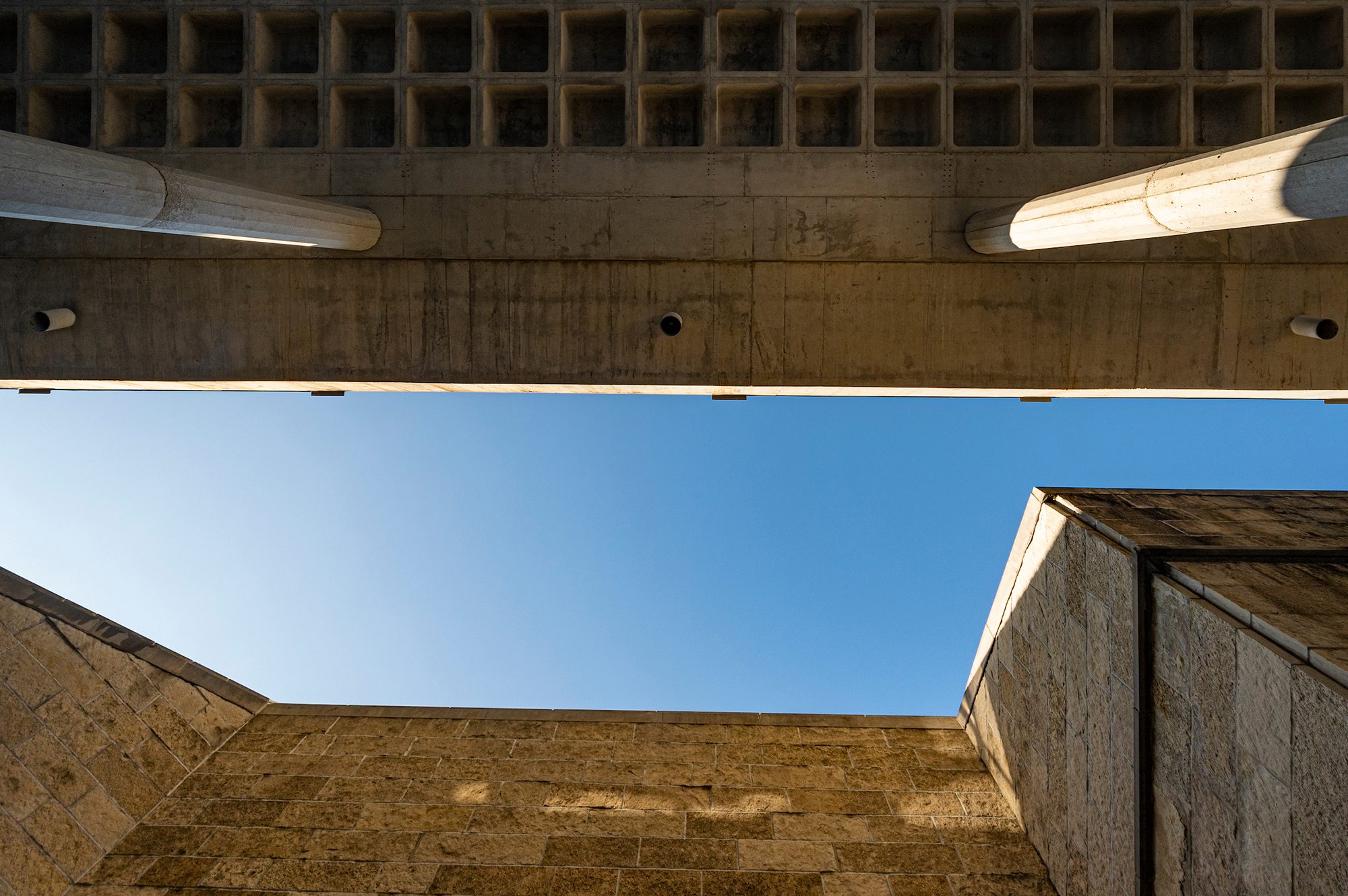 Upwards view of sky through Humanities building structures