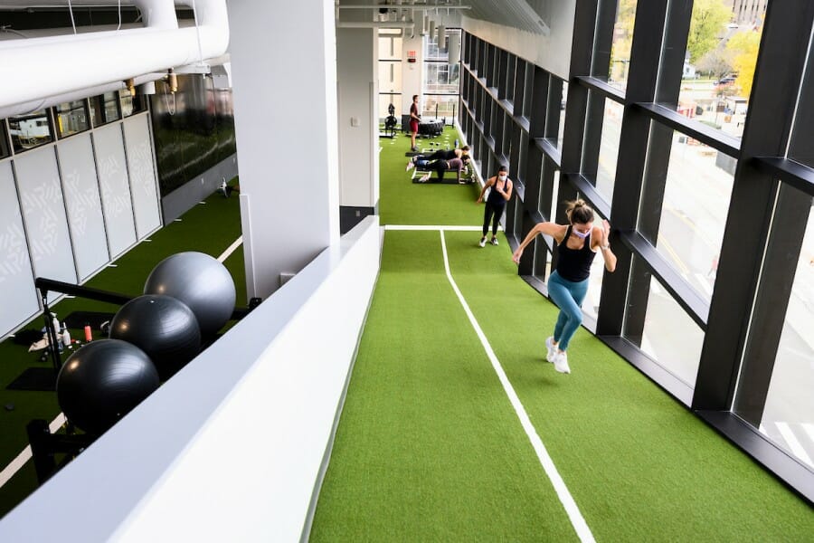 Students run incline sprints while working out in the turf movement area at the Nick