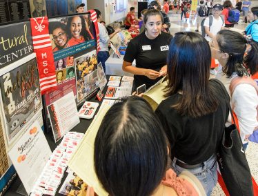 Students check out the Multicultural Student Center booth during the Fall Student Organization Fair at the Kohl Center at the University of Wisconsin-Madison