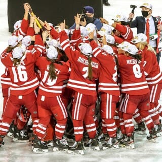 UW Women's hockey team embraces on the ice